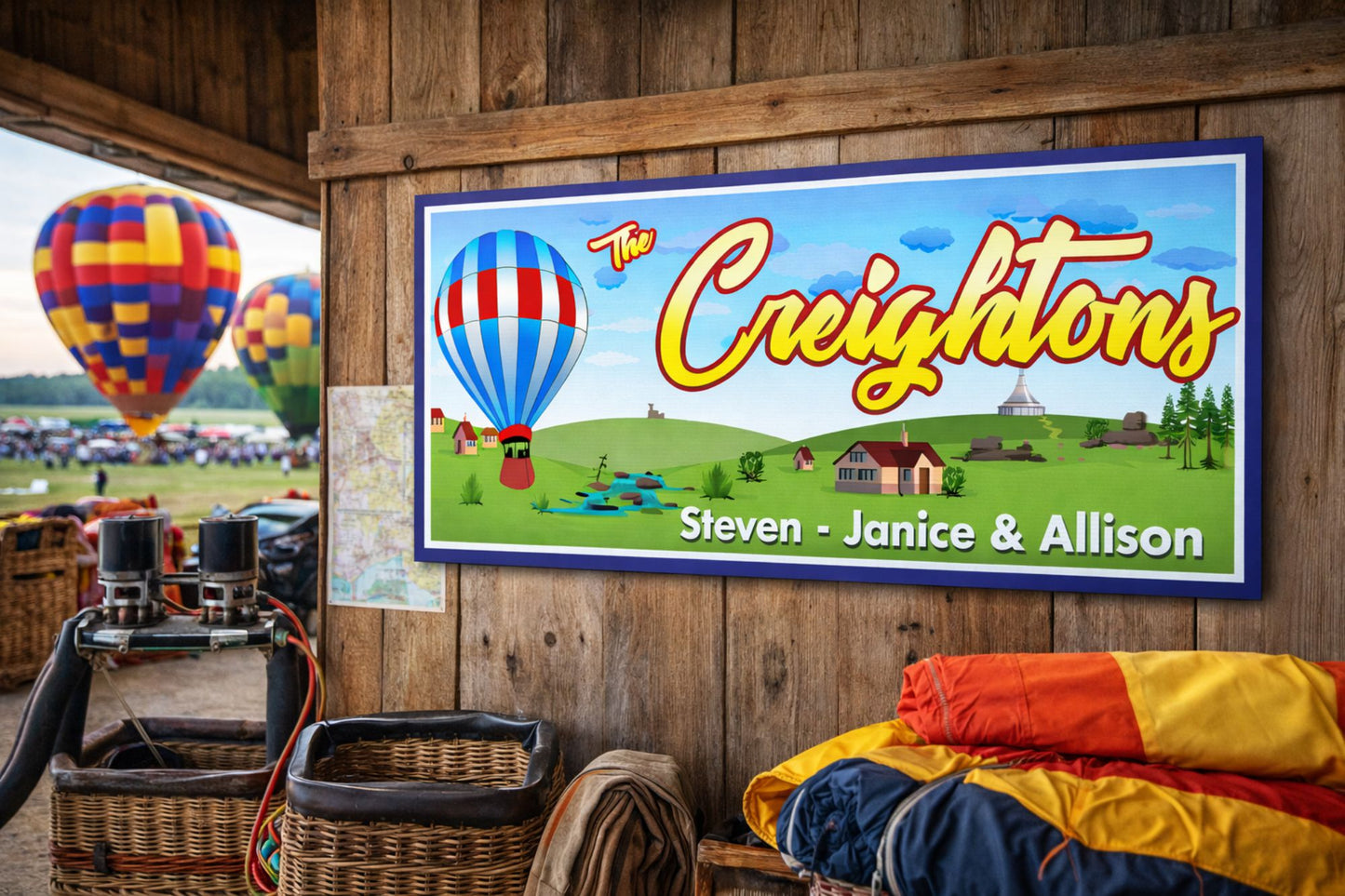 Custom family name sign mounted on a rustic barn wall with hot air balloons in the background at a countryside festival