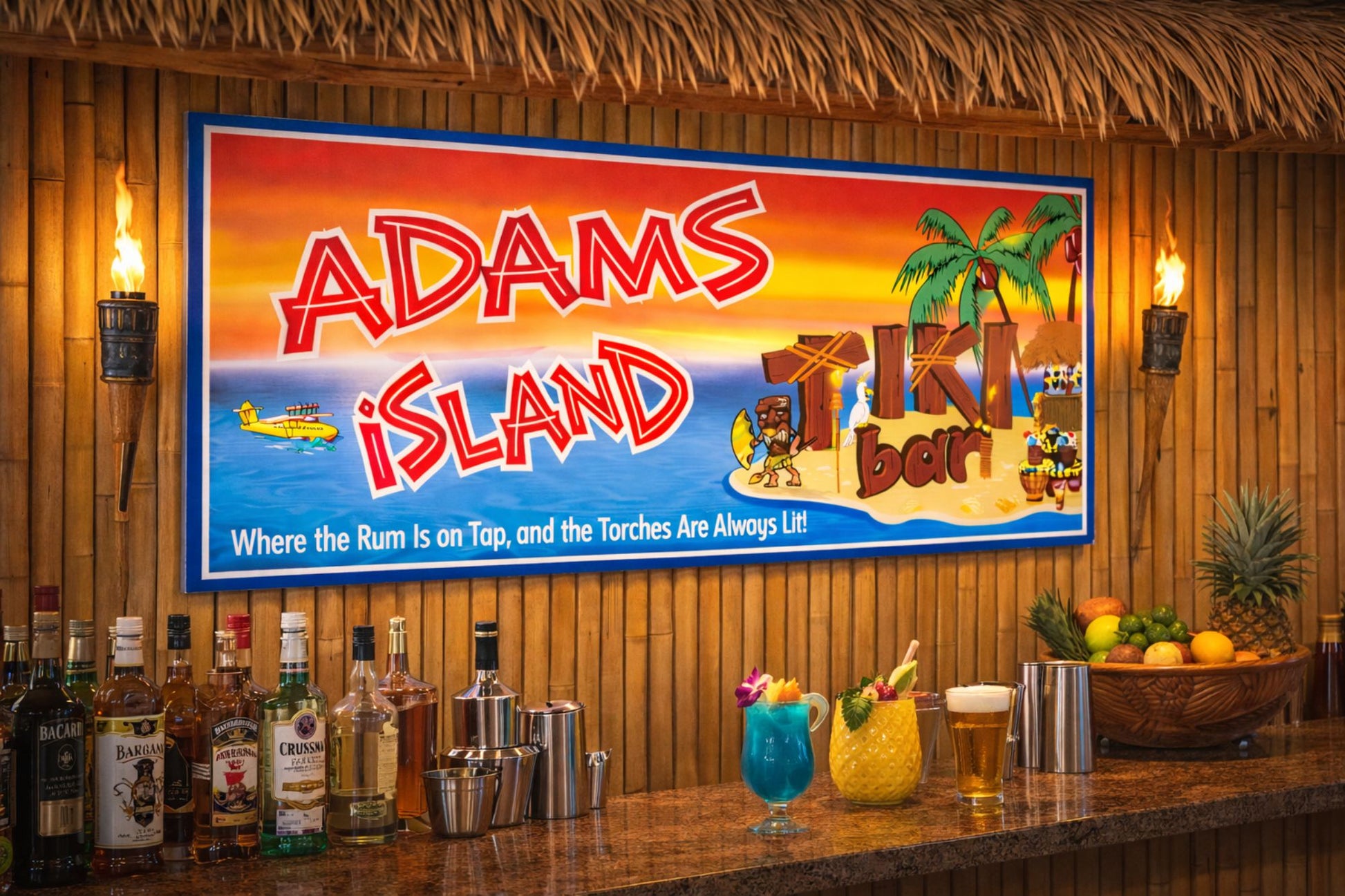 Tiki bar island sign displayed in a tropical bar setting with bamboo walls, liquor bottles, and island decor.
