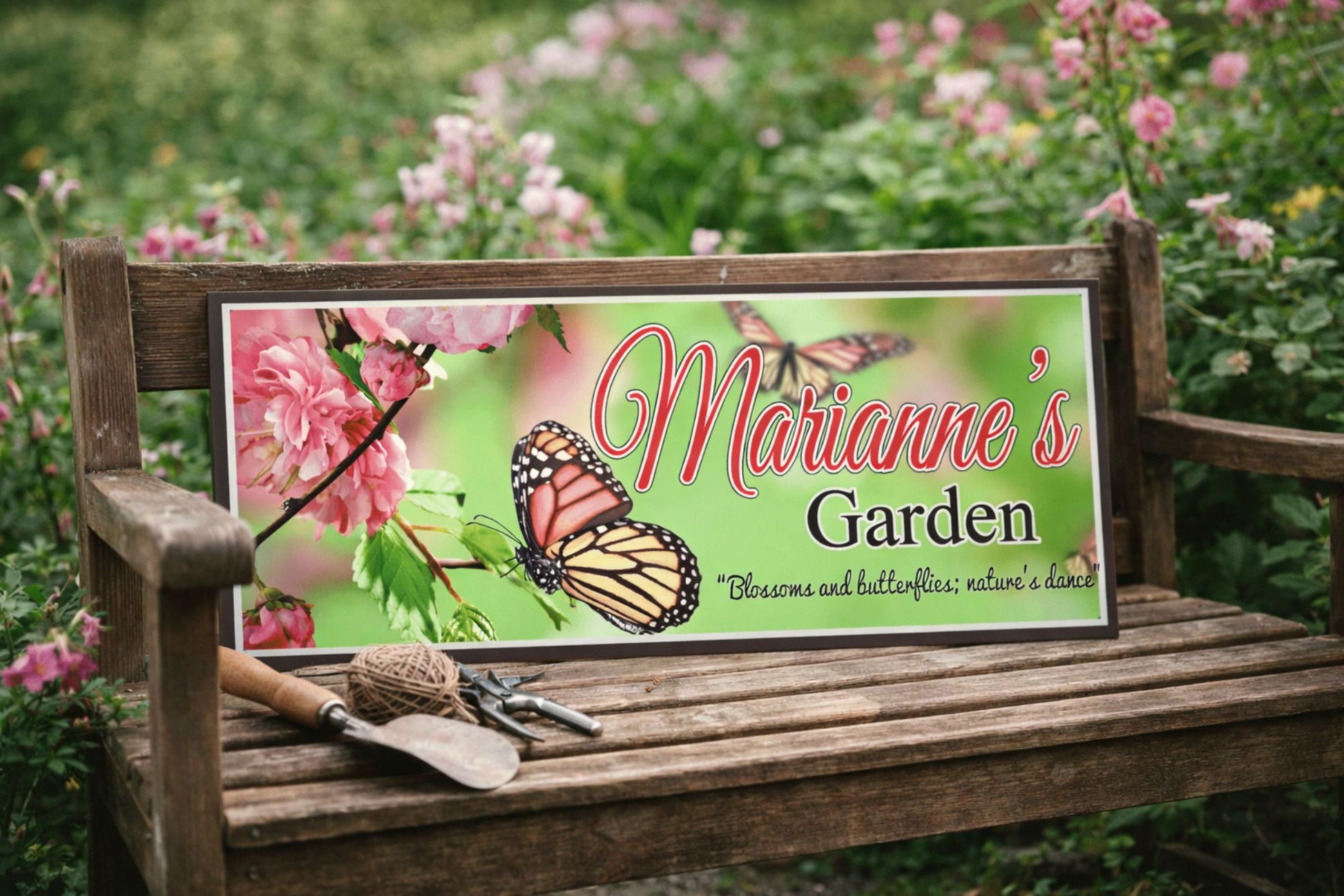 Custom garden sign resting on a wooden bench surrounded by blooming flowers