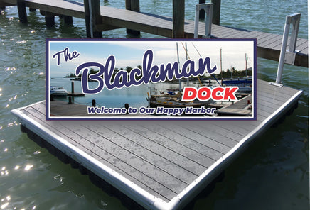 Personalized dock sign depicting a classic marina scene with a pier and rows of boats, set against a backdrop of a shoreline lined with tall palm trees. The sign features a custom name in red over the word 'Dock,' with an optional tagline beneath