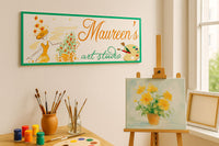 Personalized art studio sign displayed above an easel in a bright home art room