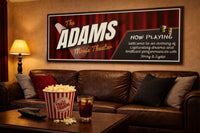 Movie theater wall sign displayed above a leather couch with popcorn and drinks in a home cinema room