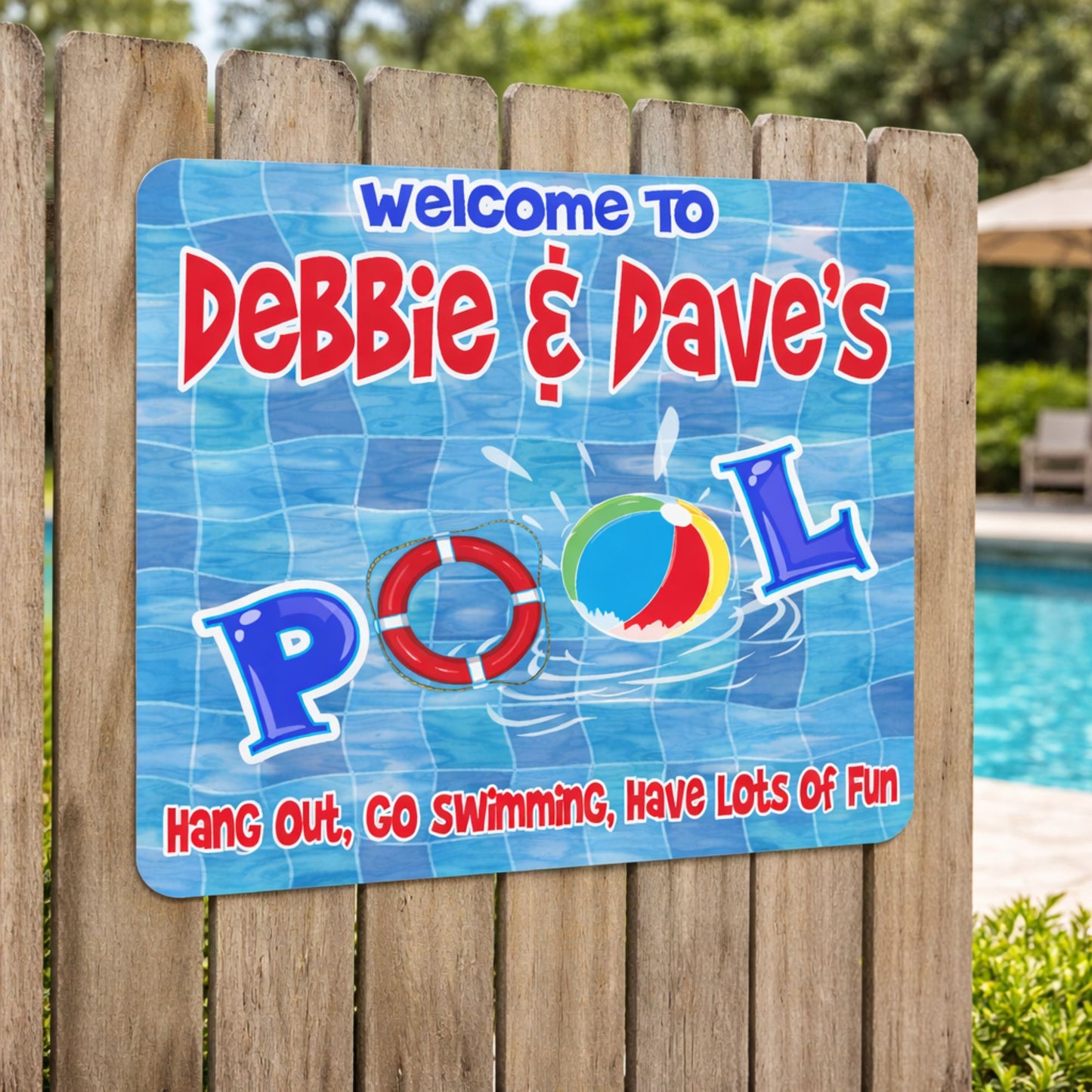 Personalized pool sign mounted on a wooden fence beside a backyard swimming pool