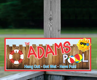 Personalized wooden fence pool sign with cartoon sun, life preserver, and beach ball details