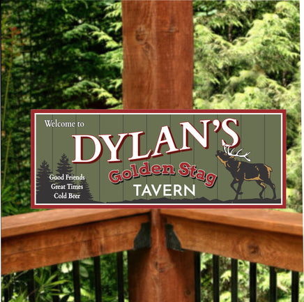 Personalized 'Golden Stag Tavern' welcome sign featuring an olive green background, pine tree silhouettes, and a buck with large white antlers, with customizable text.