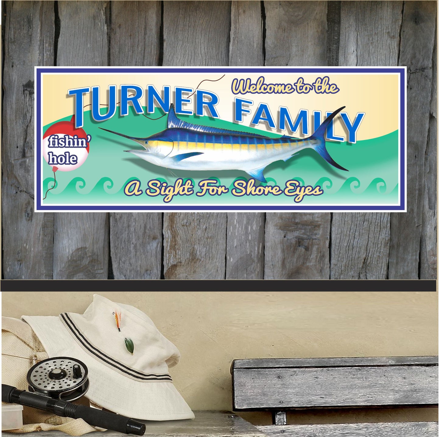 Personalized coastal fishing sign mounted on a rustic wooden wall with a large sport fish illustration, fishing float graphic, and customizable family text, displayed above a bench with fishing gear and a hat