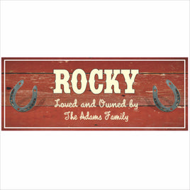 Personalized horse stall name sign with rustic red wood background and horseshoes