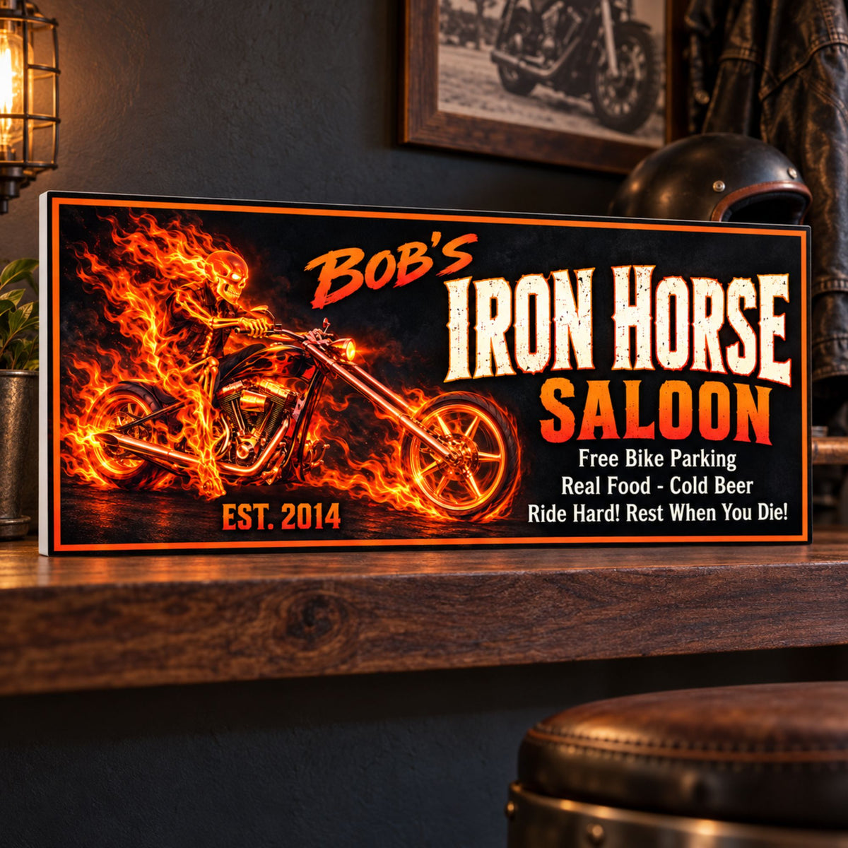 Iron Horse Saloon sign displayed on a dark wood shelf in a biker lounge, with a subtle white PVC edge, leather jacket, and motorcycle helmet.