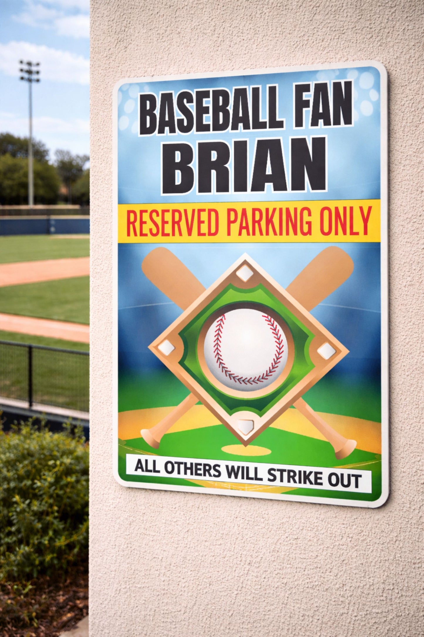 Personalized aluminum baseball fan reserved parking sign with custom name mounted on an exterior wall near a baseball field