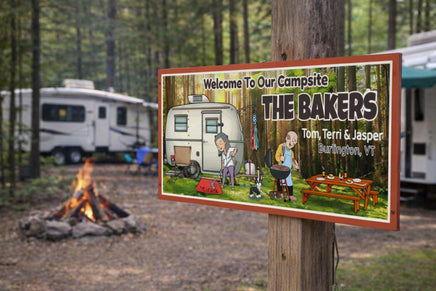 Personalized campsite sign mounted on a wooden post at a forest campsite, with RVs, picnic area, and campfire in the background.