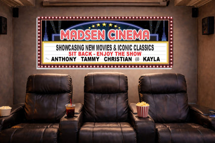 Personalized cinema marquee wall sign displayed above reclining theater chairs in a home movie room