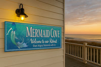 Custom mermaid wall sign displayed on an outdoor beach house wall at sunset