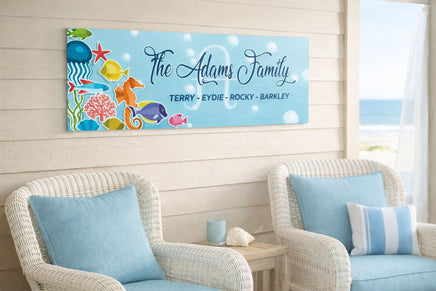 personalized ocean family name sign hanging on a beach house wall above wicker chairs