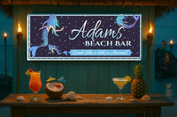 Beach Bar sign with mermaid graphics and cocktails on a wooden table.