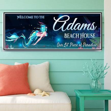 mermaid beach house sign displayed on aqua shiplap wall above coastal outdoor bench with coral pillow, seashells, and turquoise side table