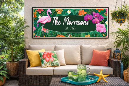 personalized flamingo family name sign displayed on a tropical patio wall with plants and summer decor
