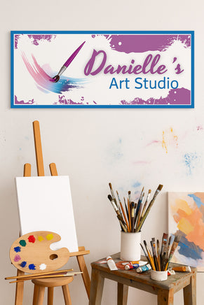 personalized art studio sign displayed above easel and paintbrushes in creative workspace