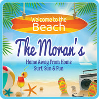 personalized beach house sign with surfboard flip flops drink and seashells on a coastal scene