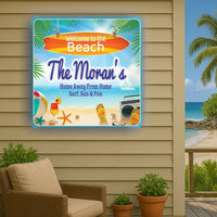 beach house sign displayed on outdoor wall next to patio chair with ocean and palm trees in background