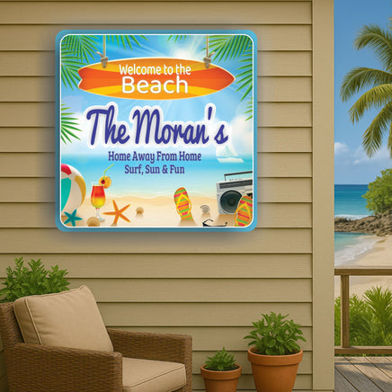beach house sign displayed on outdoor wall next to patio chair with ocean and palm trees in background