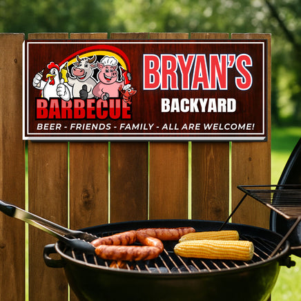 personalized backyard barbecue sign with farm animals hanging on wooden fence above grill with sausages and corn