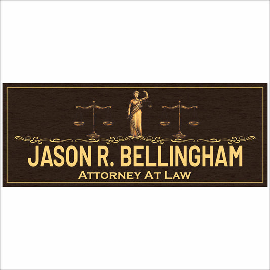 close up of custom attorney sign with gold lettering and lady justice and scales on dark wood background