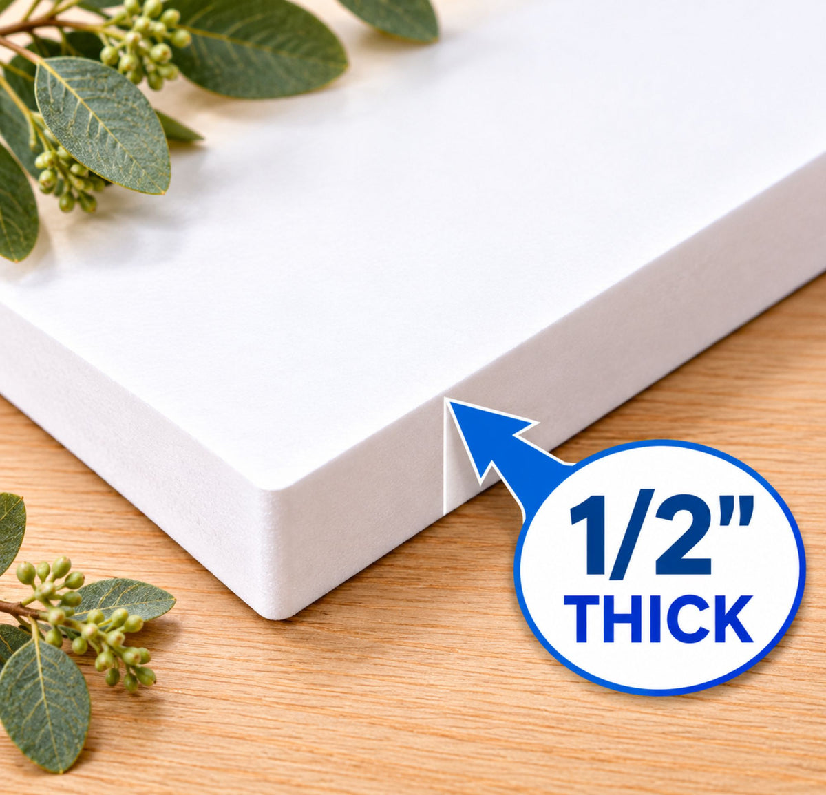 Close-up of durable white 1/2-inch KomaCel PVC sign material, showing the solid rigid edge and thickness against a wood surface.