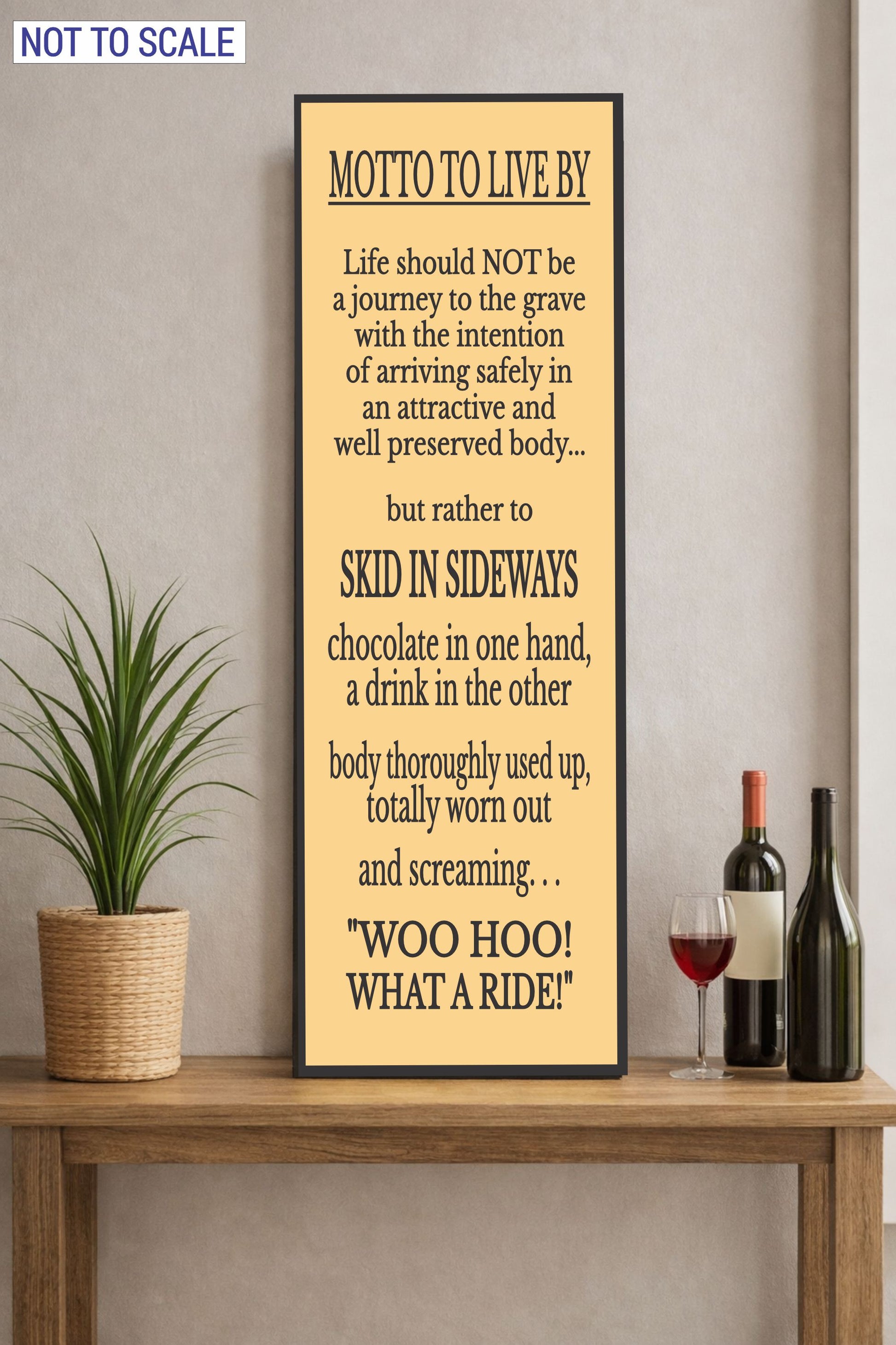 motto to live by funny sign on tabletop with plant and wine bottle