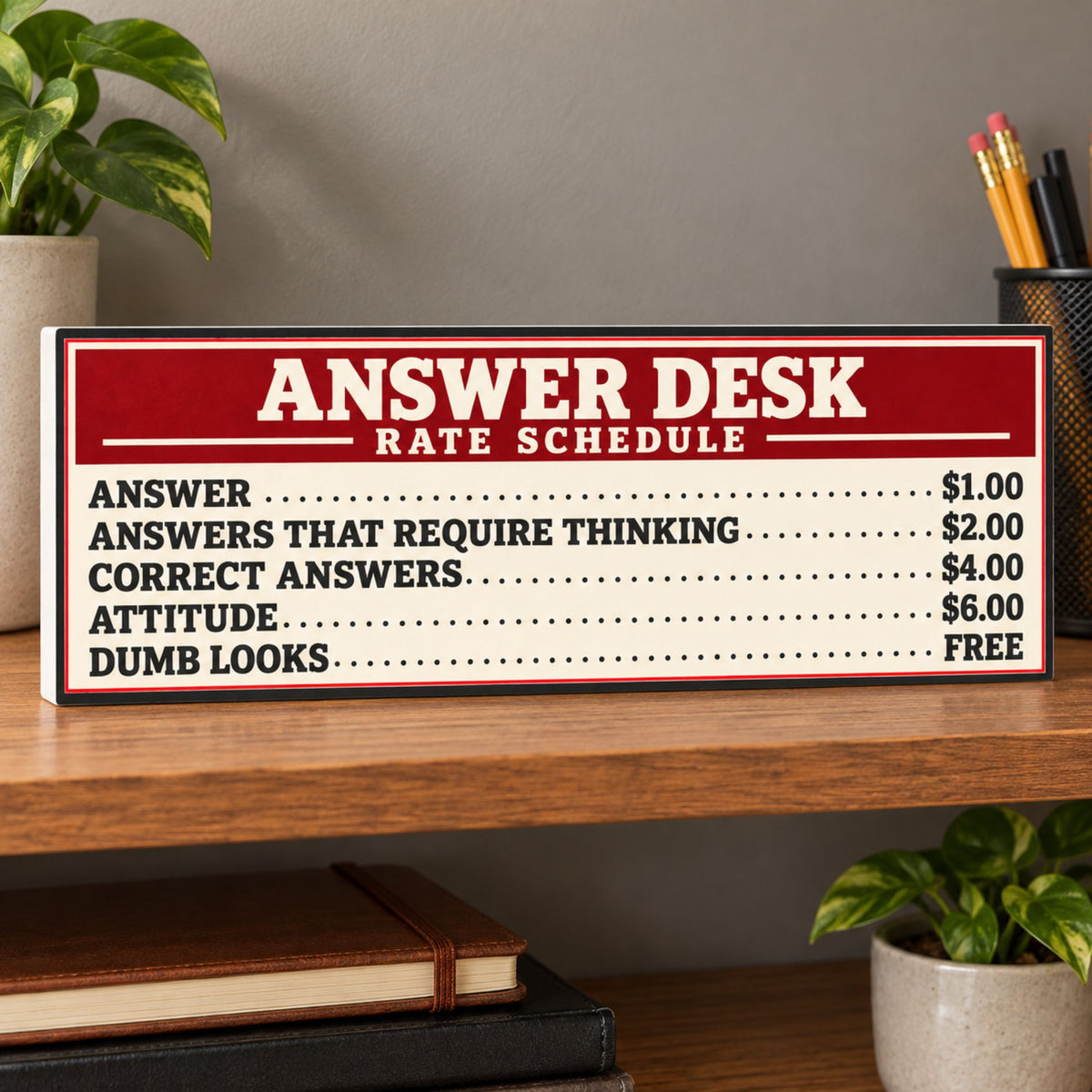 Answer Desk Rate Schedule sign on a wooden office shelf with plants, books, and a pencil cup, showing a subtle white PVC edge on the left.