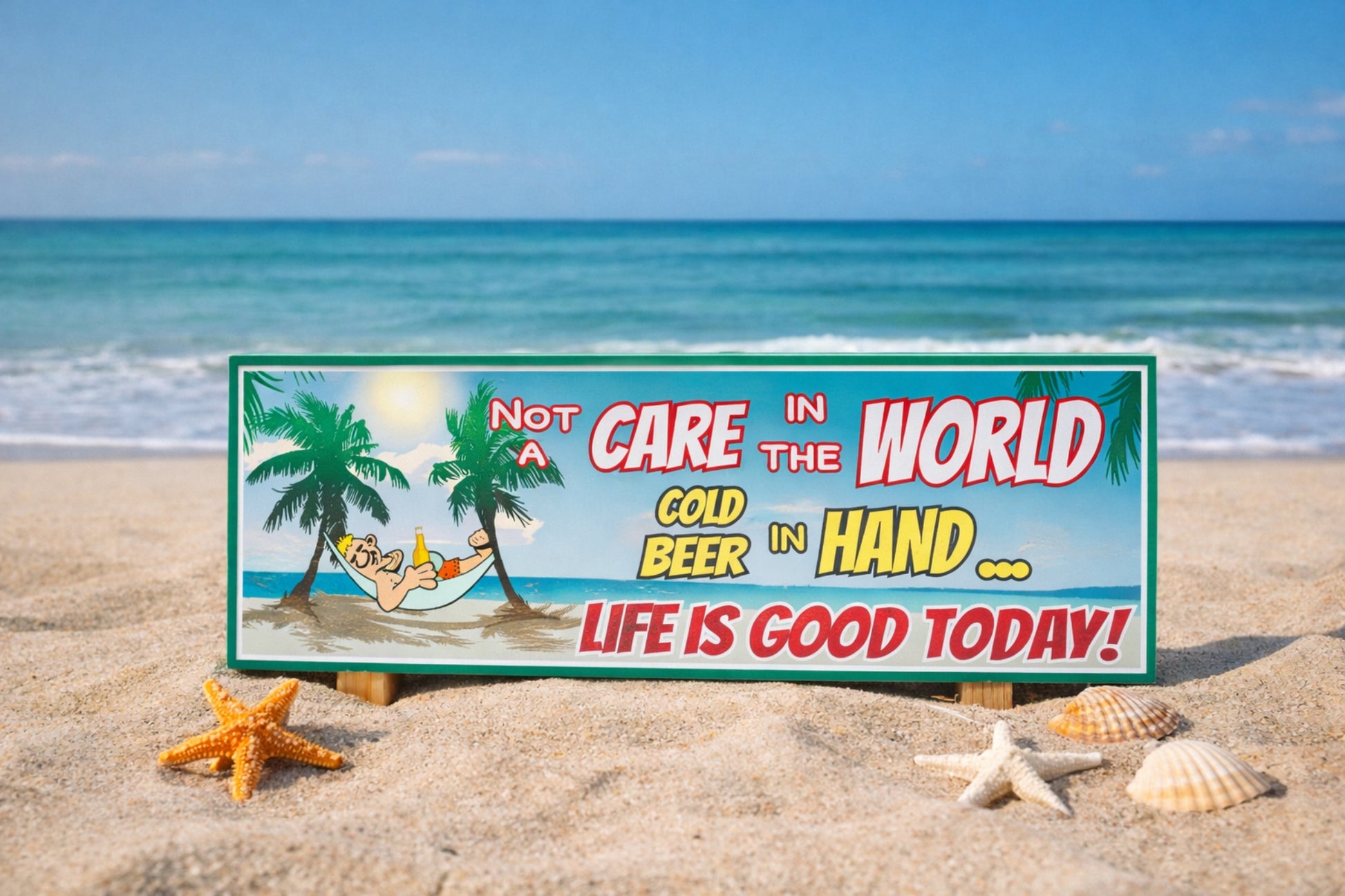 close up of tropical beach sign sitting in sand with starfish and seashells in foreground ocean waves and blue sky in background