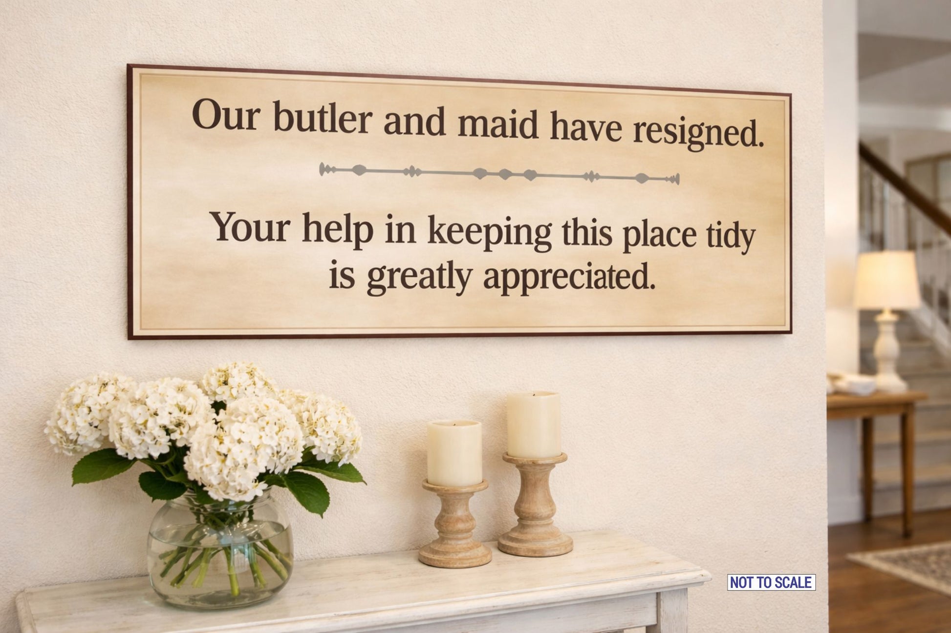guest room humor sign displayed above console table with flowers and candles