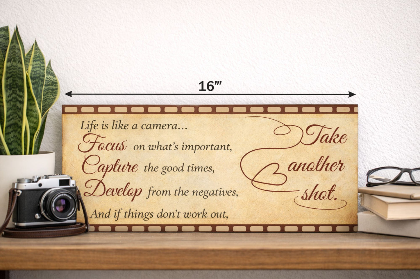 lifestyle image of inspirational quote sign on shelf with camera plant and books photography themed decor