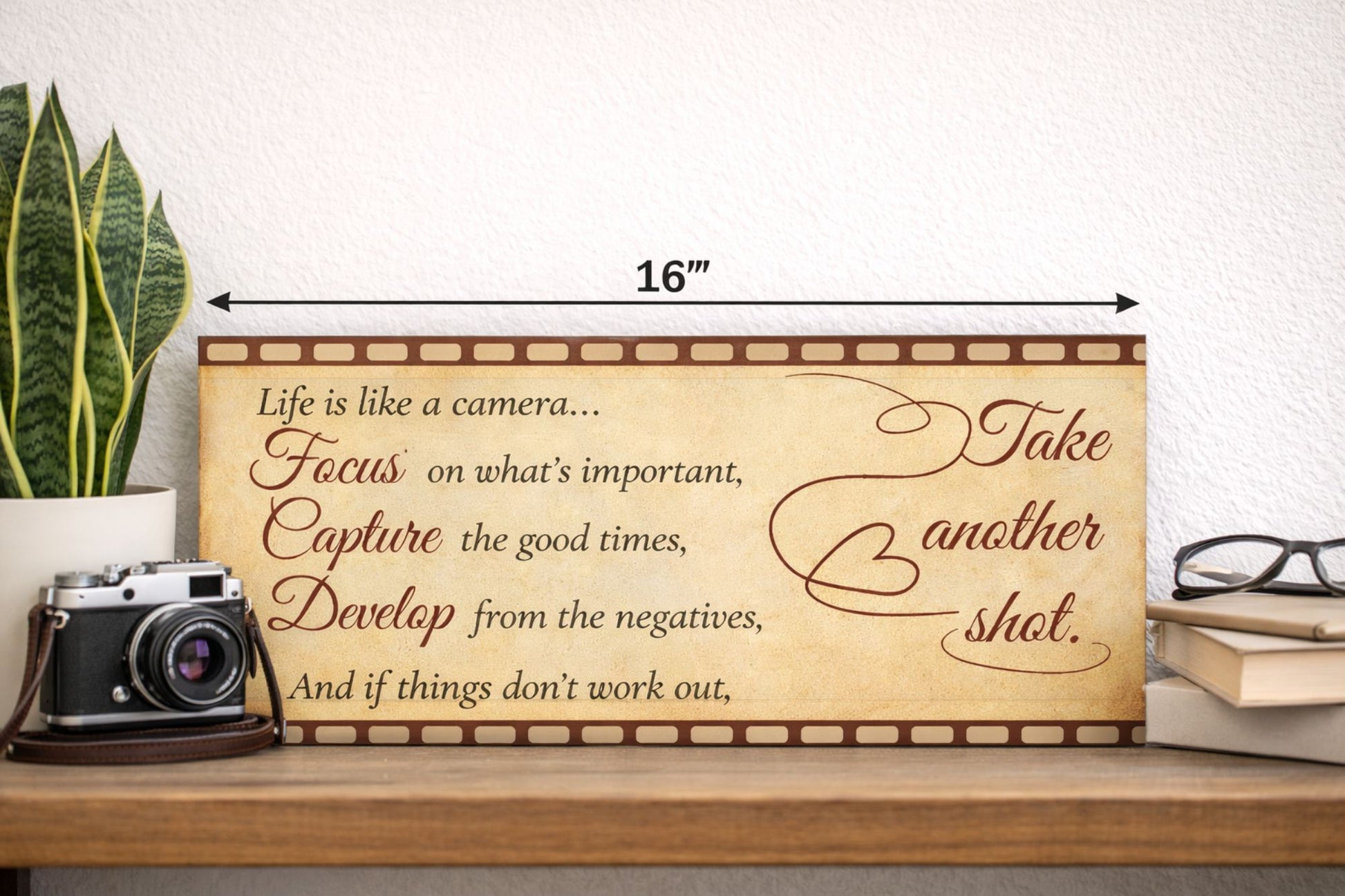 lifestyle image of inspirational quote sign on shelf with camera plant and books photography themed decor