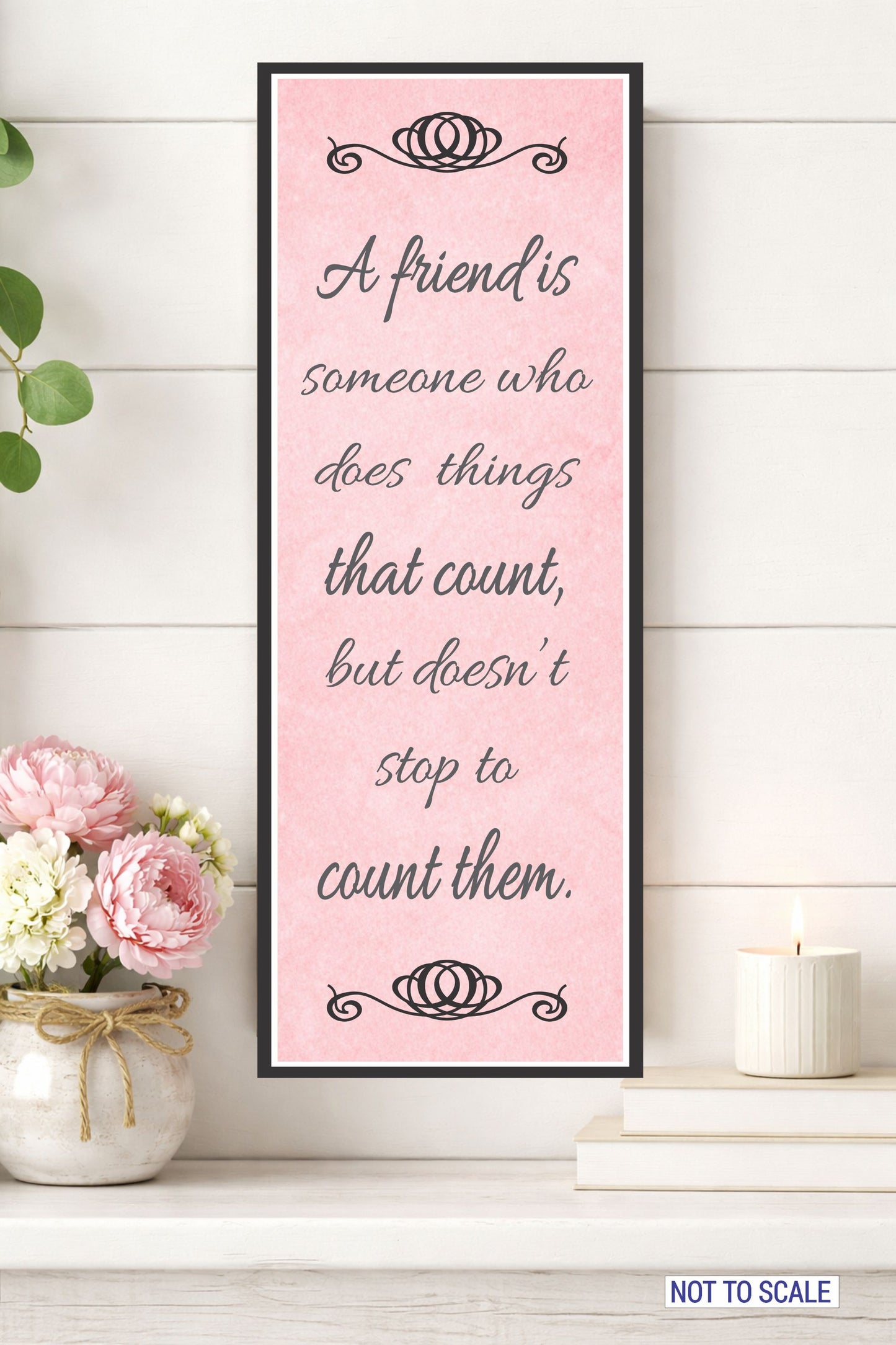 Friendship quote wall sign displayed above shelf with flowers and candle decor