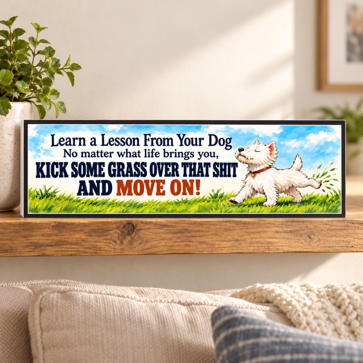 Black-bordered funny motivational sign displayed on a wooden shelf beside a potted plant in a cozy living room.