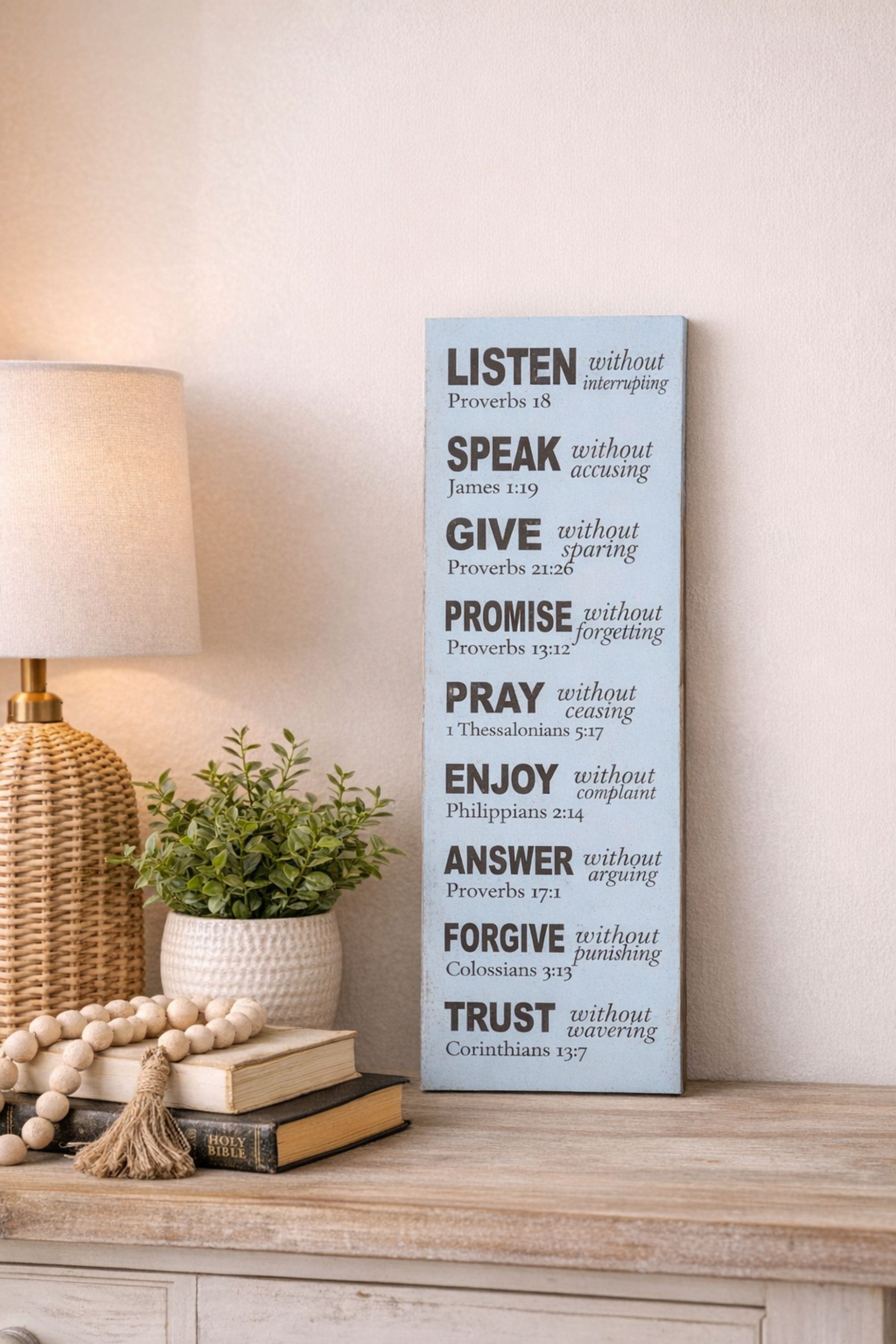 Christian Bible verse virtues sign displayed on table with lamp plant and books