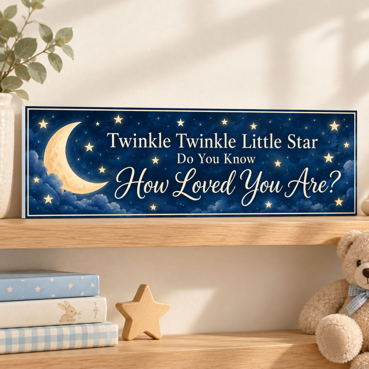 Moon and stars nursery sign resting on an oak shelf with a subtle white PVC edge, children’s books, a wooden star, and a teddy bear.