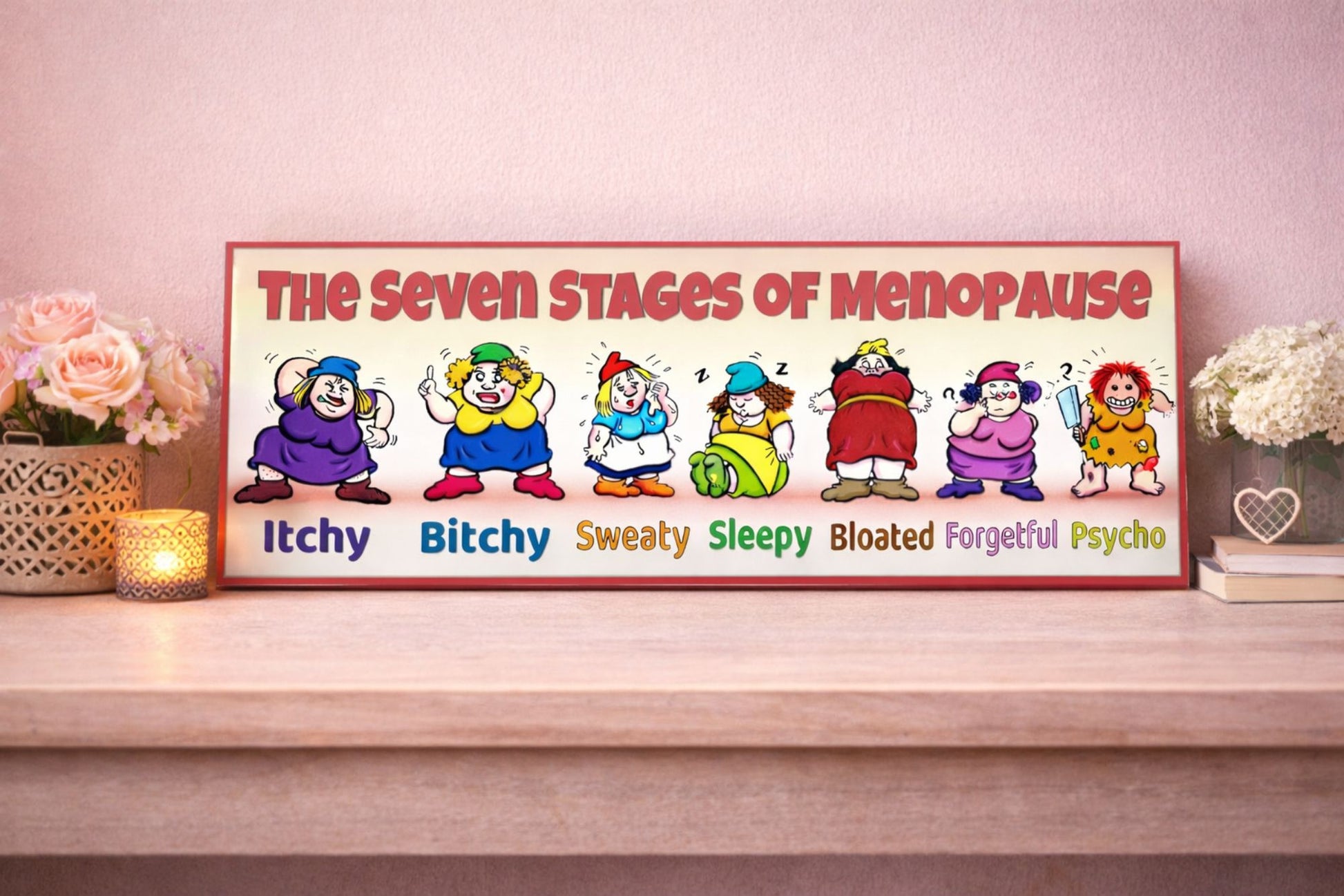 seven stages of menopause sign funny women gift displayed on shelf with pink wall flowers and candle feminine decor