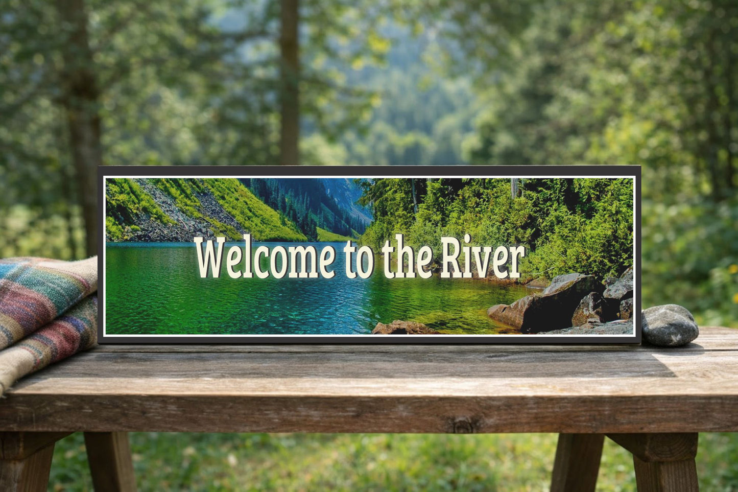 river cabin sign displayed on outdoor wooden bench with trees and natural setting
