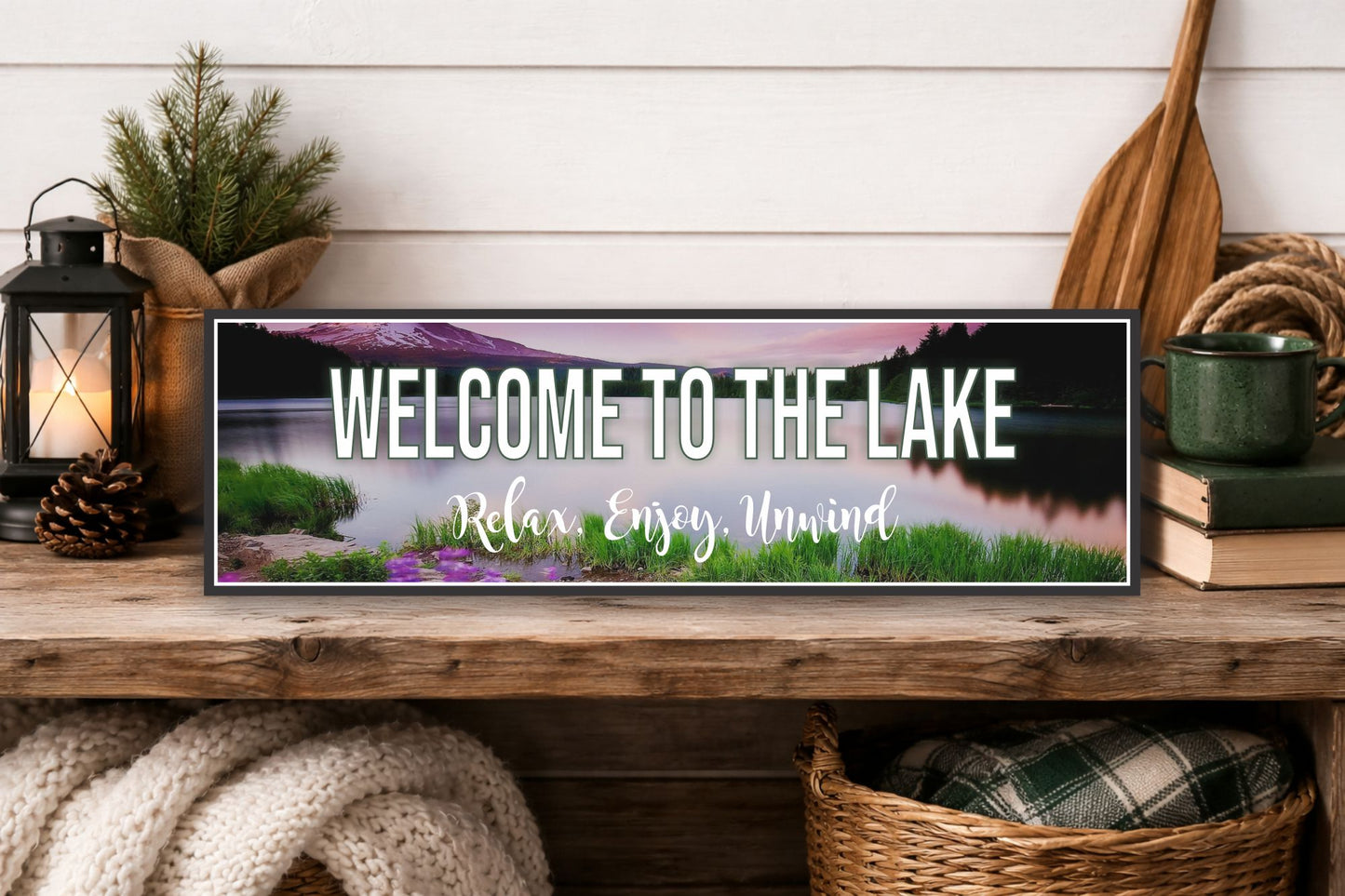 Welcome to the lake sign displayed on rustic wood shelf with lantern and cozy cabin decor