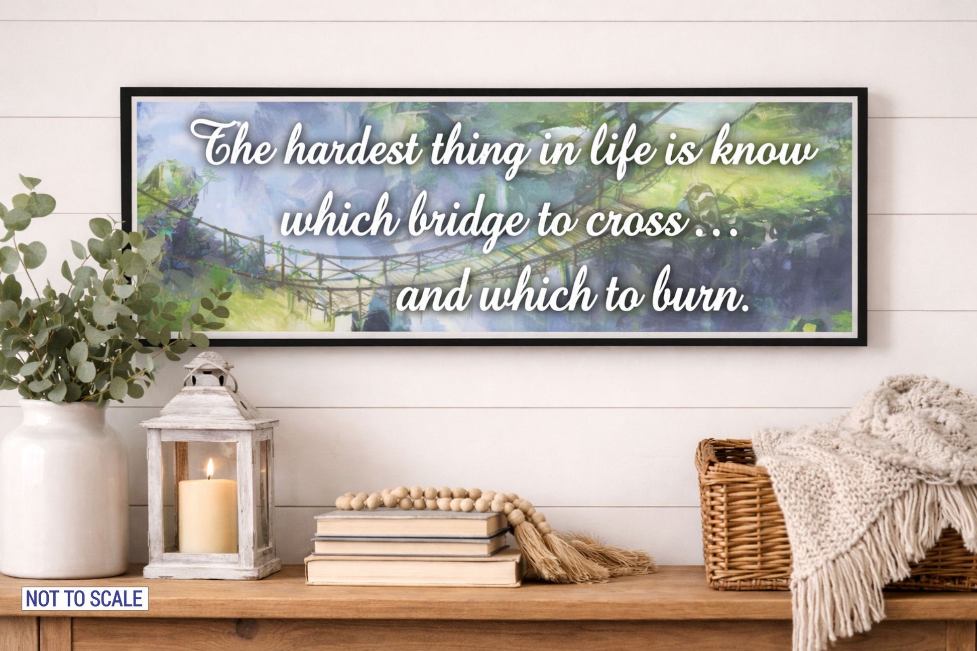 Inspirational life quote bridge wall sign displayed above a rustic console table with lantern books and greenery decor