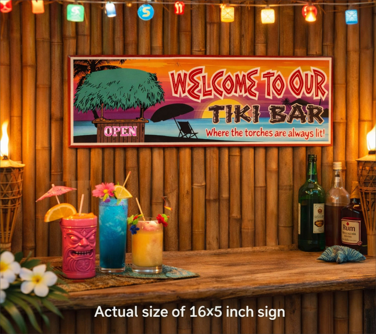 16x5 tiki bar sign mounted on bamboo wall above bar counter with tropical drinks and tiki torches for scale