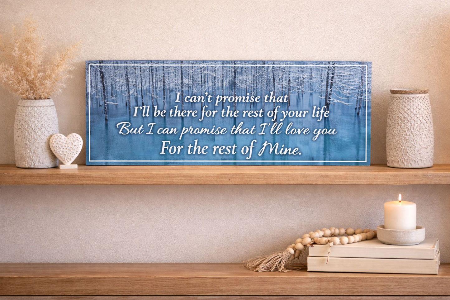 Romantic love quote sign displayed on wooden shelf with neutral decor and candle styling