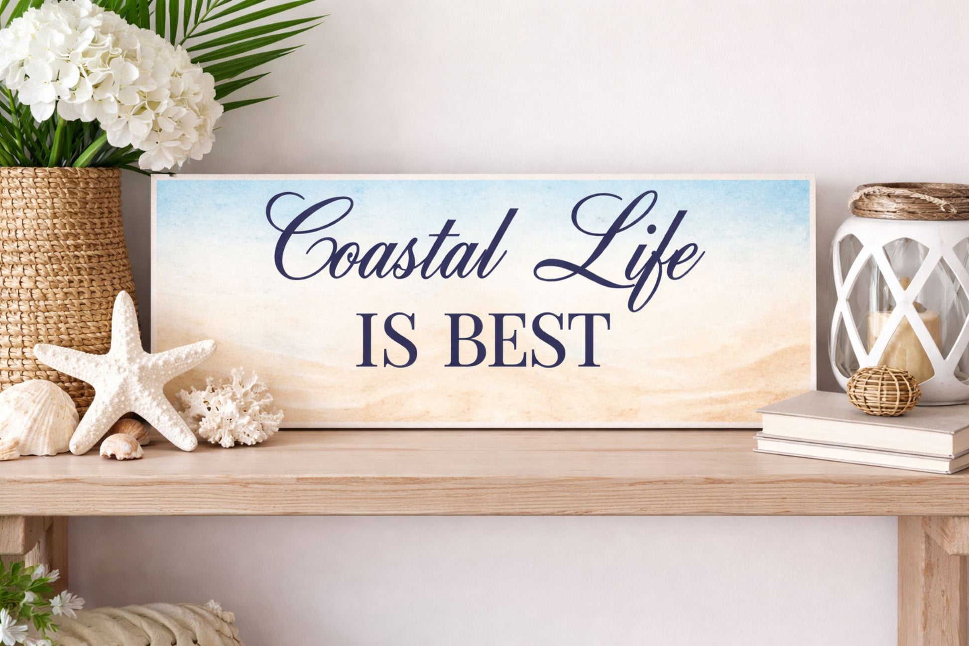coastal life is best sign displayed on shelf with beach decor and neutral styling