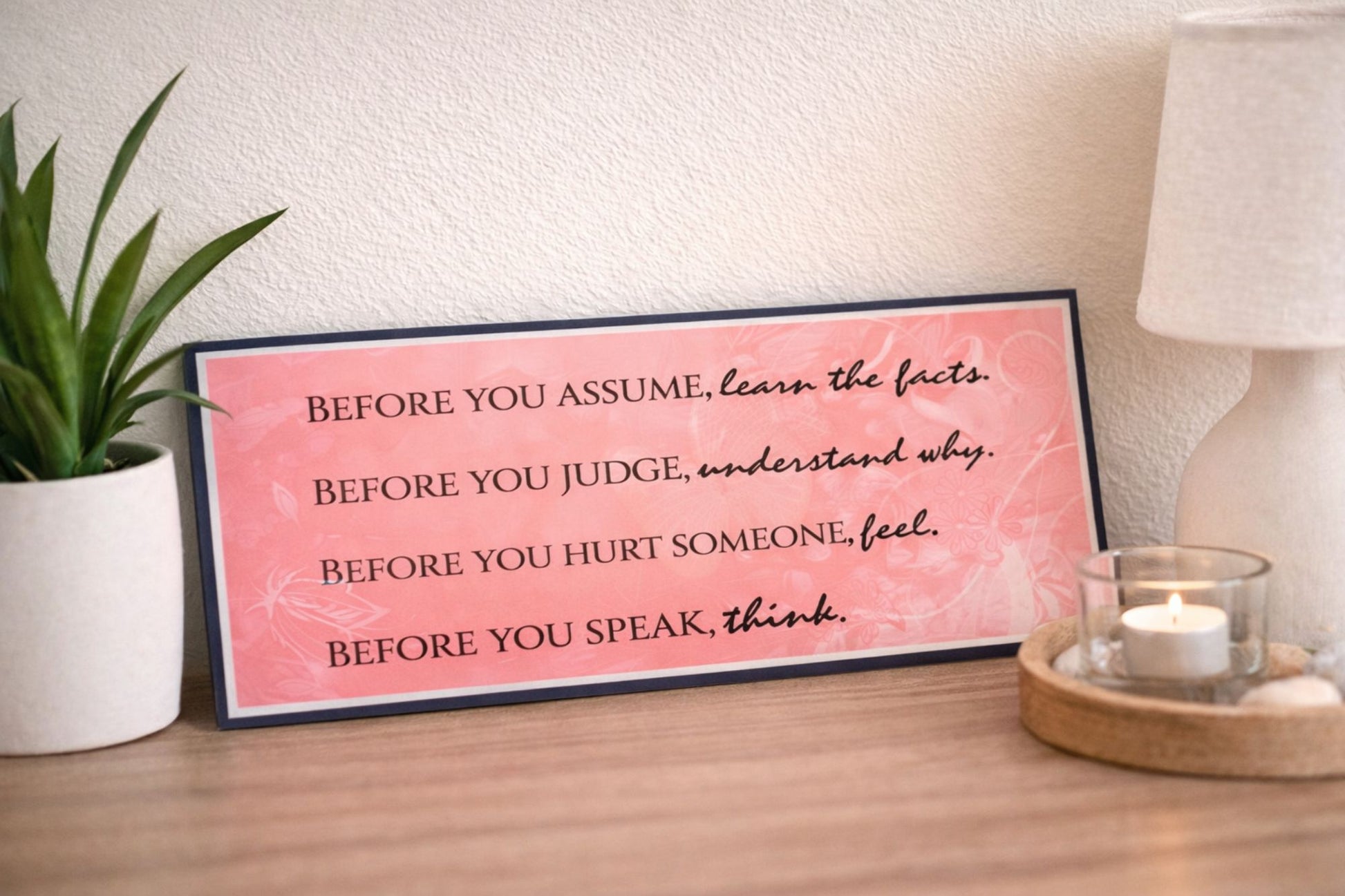 Inspirational kindness quote wall sign on shelf with plant and candle decor