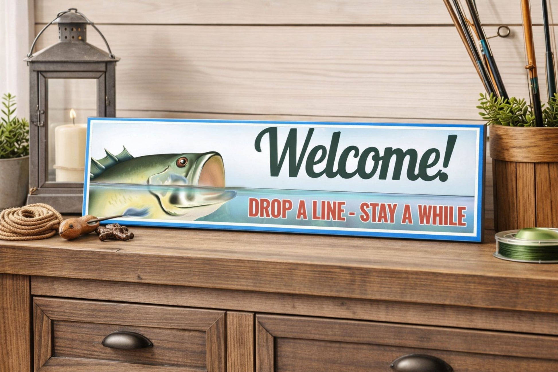 fishing welcome sign with bass illustration on wooden console table with lantern and fishing gear