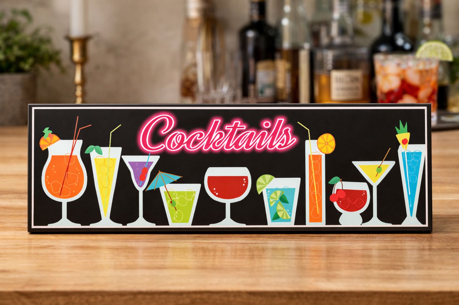 cocktail bar sign displayed on bar countertop with bottles and glassware in background