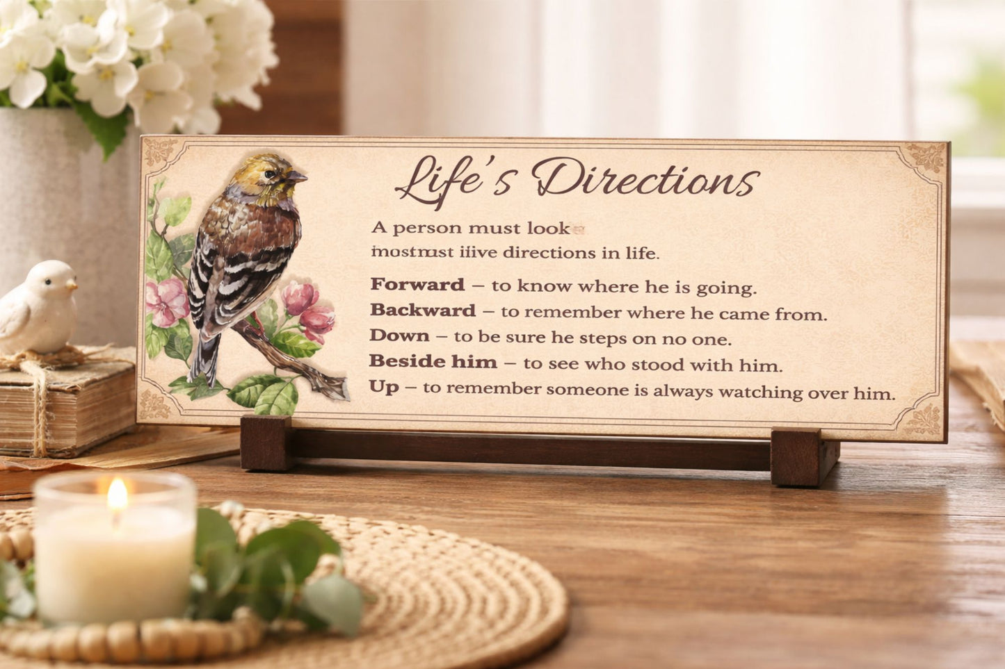 life's directions inspirational sign displayed on table with candle flowers and books