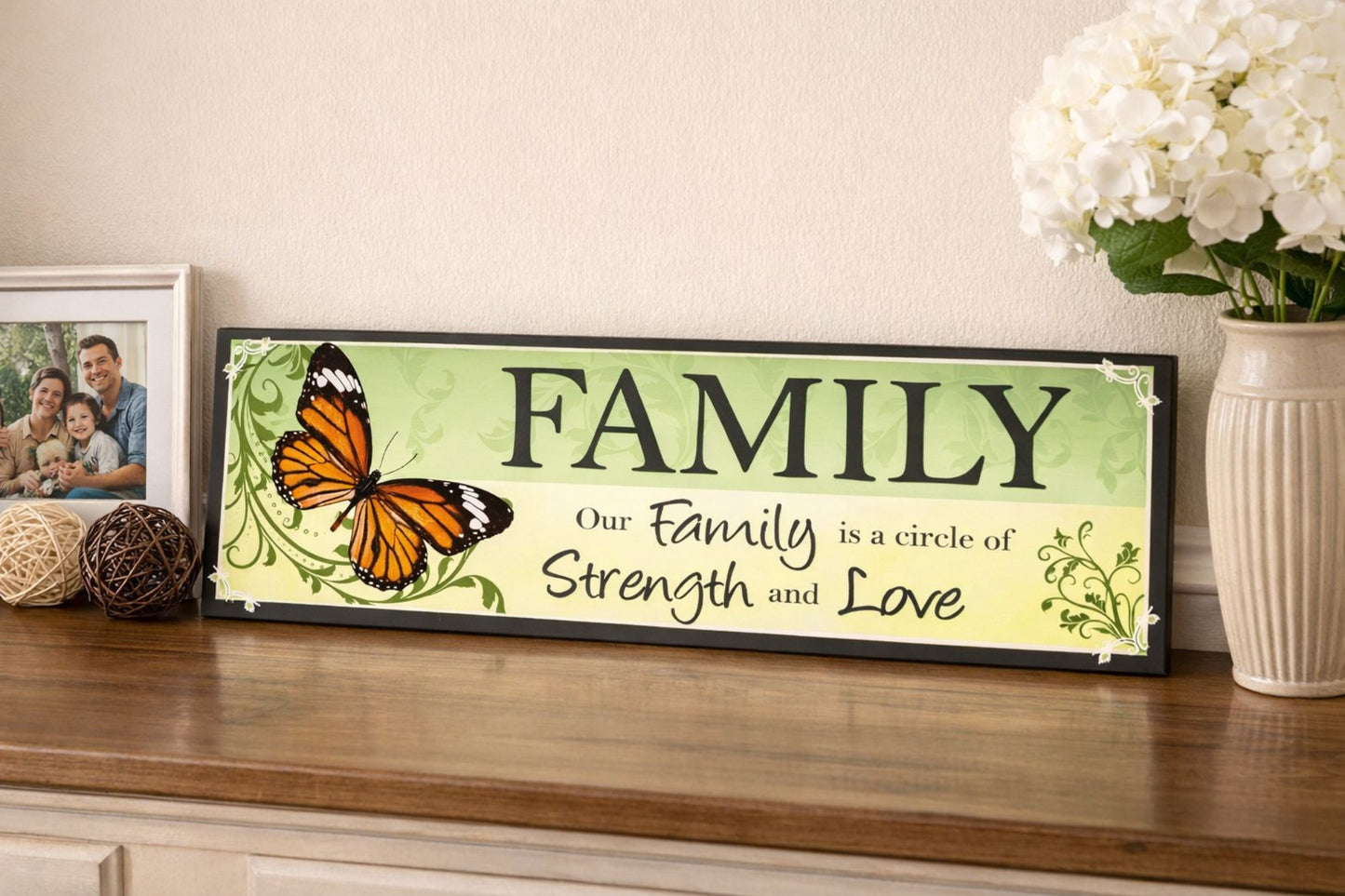 family quote sign displayed on wood table with framed photo and flowers in background