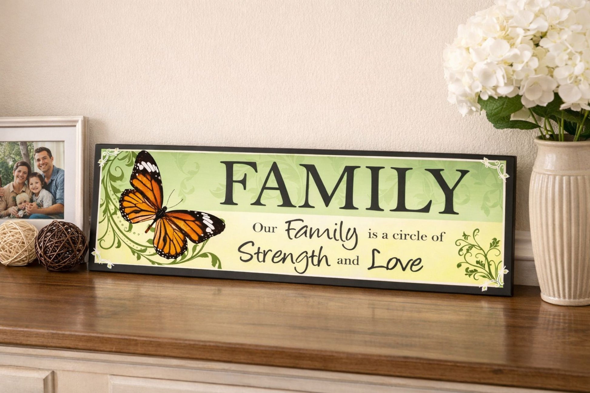 family quote sign displayed on wood table with framed photo and flowers in background